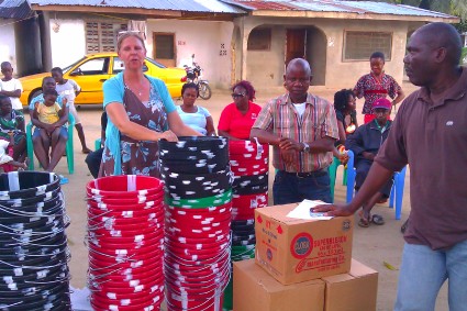 Irish humanitarian Mrs. Adrienne Blomberg-Sarwahpue (along with Mr. Sarwahpue, middle) donating hand washing buckets and other anti-Ebola materials to the Gaye Dukpaye Community last September as Chairman Benedict Bropleh looks on